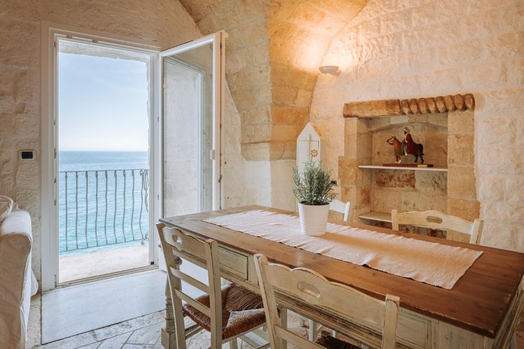 a dining room with a table and a large window at Tre Archi Suite & Relais in Polignano a Mare