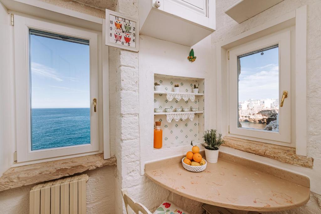 a room with a table and two windows at Tre Archi Suite & Relais in Polignano a Mare