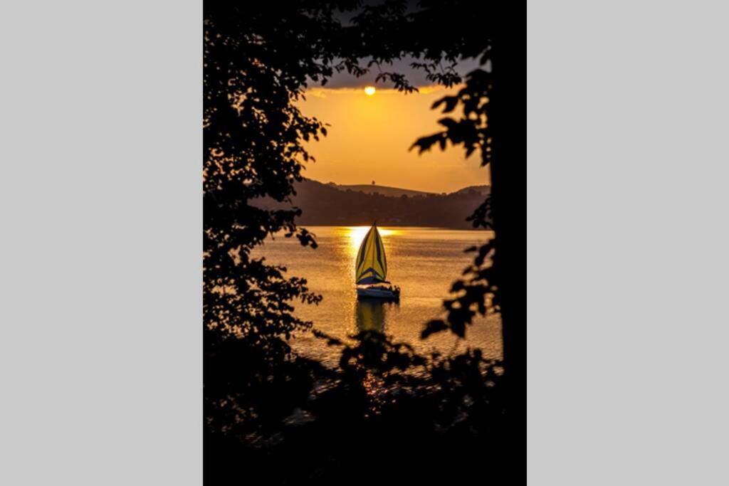 - un voilier dans l'eau au coucher du soleil dans l'établissement The Lake House - dom nad samym Jeziorem Rożnowskim, à Znamirowice