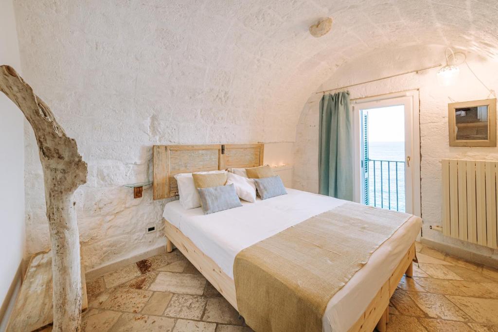a bedroom with a bed in a room with a window at Tre Archi Suite & Relais in Polignano a Mare