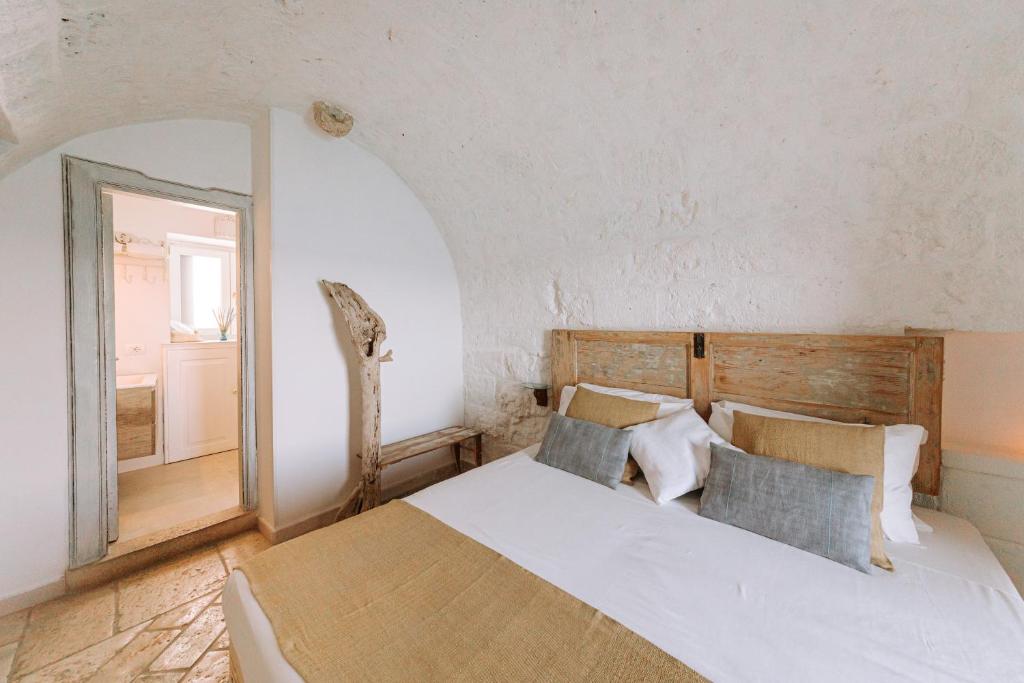 a bedroom with a large bed and a mirror at Tre Archi Suite & Relais in Polignano a Mare