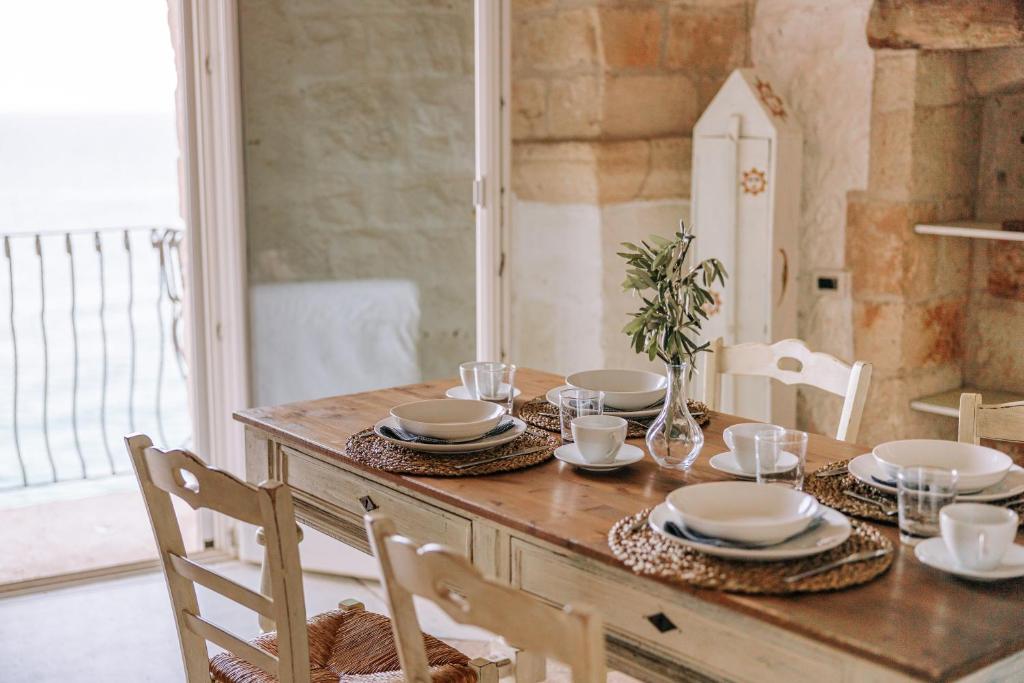 a wooden table with plates and dishes on it at Tre Archi Suite & Relais in Polignano a Mare
