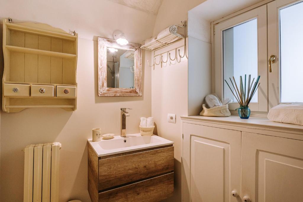 a bathroom with a sink and a mirror at Tre Archi Suite & Relais in Polignano a Mare