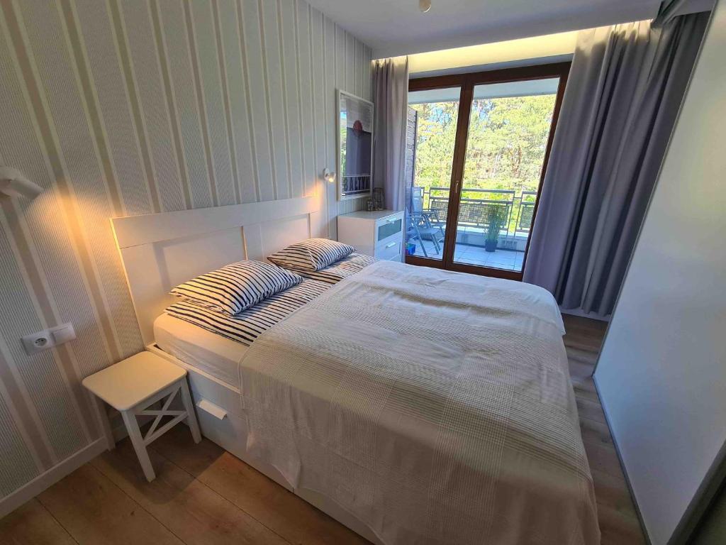 a bedroom with a large bed and a window at Apartament Jurata Deluxe in Jurata