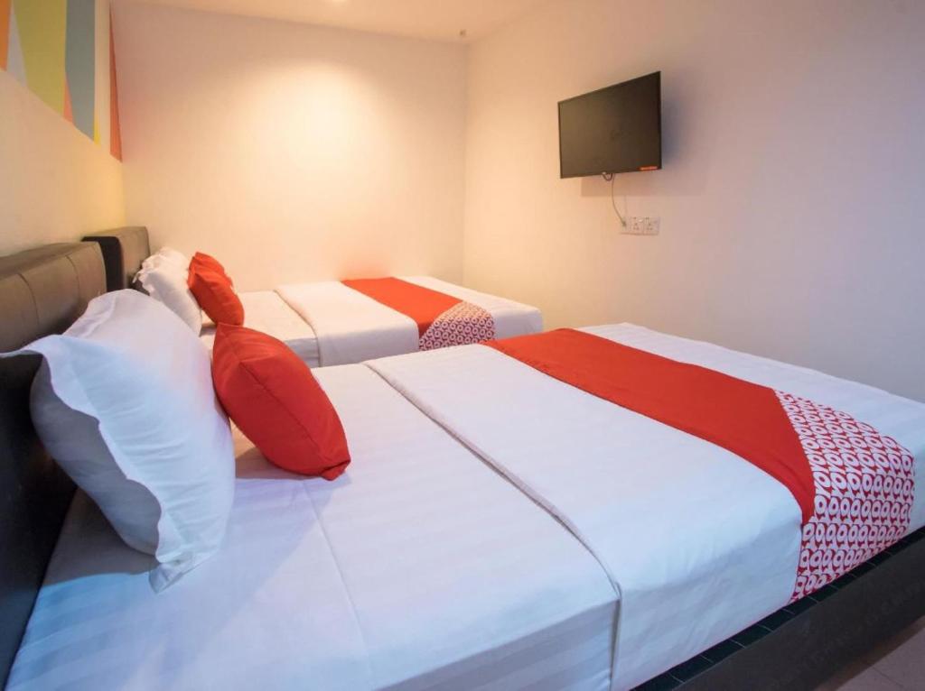 - une chambre avec 2 lits dotés d'oreillers rouges et blancs dans l'établissement OYO 90281 Hotel Taj seksyen 13, à Shah Alam