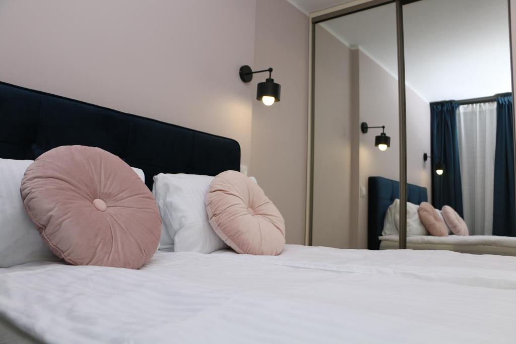 a bedroom with a bed with two pink pillows on it at Apartament Matejki 17 - Insel Apartamenty in Świnoujście