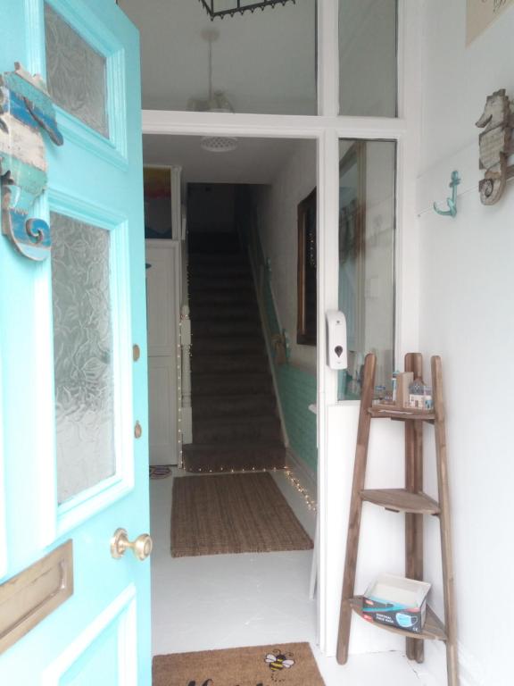 a blue door with a staircase in a room at Happy Seaside Days in Combe Martin, Devon in Combe Martin