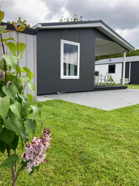 un bâtiment gris avec une terrasse dans une cour dans l'établissement Haus Moseltraum, à Coblence