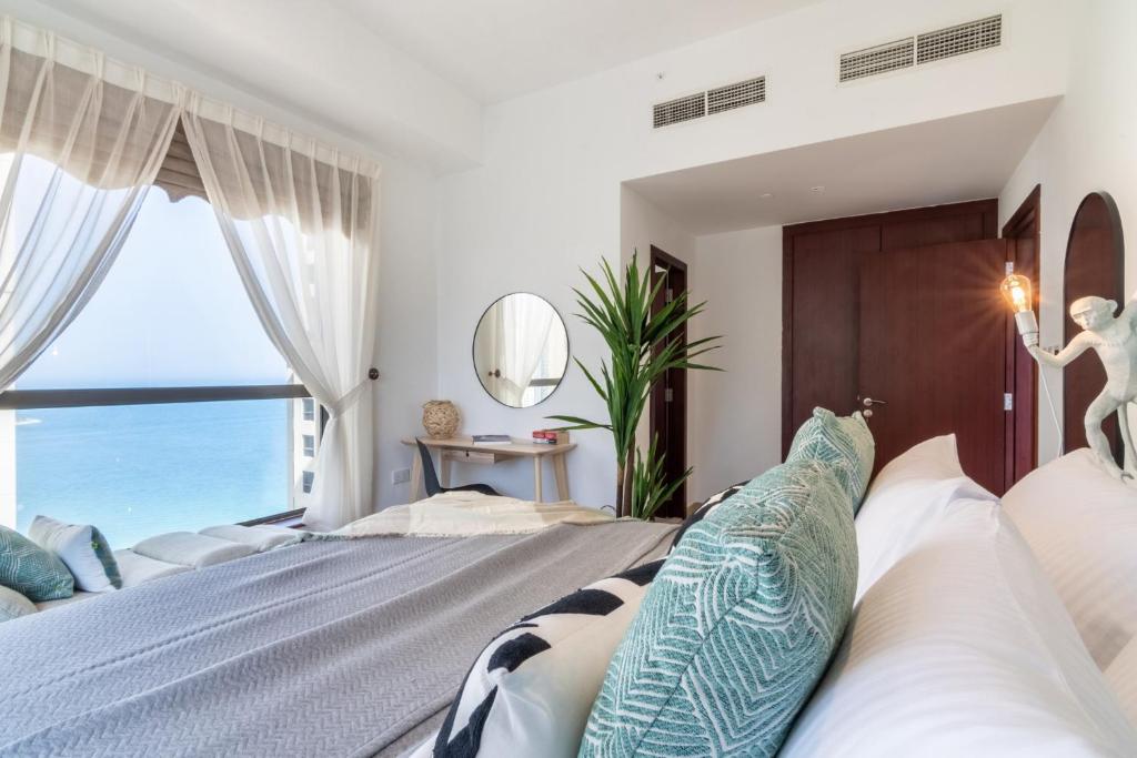 a bedroom with a large bed with a view of the ocean at The Smart Concierge - Bahar 6 in Dubai
