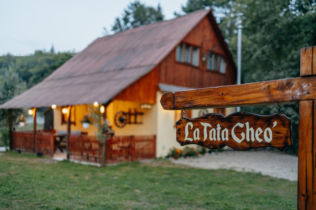 a barn with a sign in front of a building at Cabana La Tata Gheo in Porumbacu de Sus
