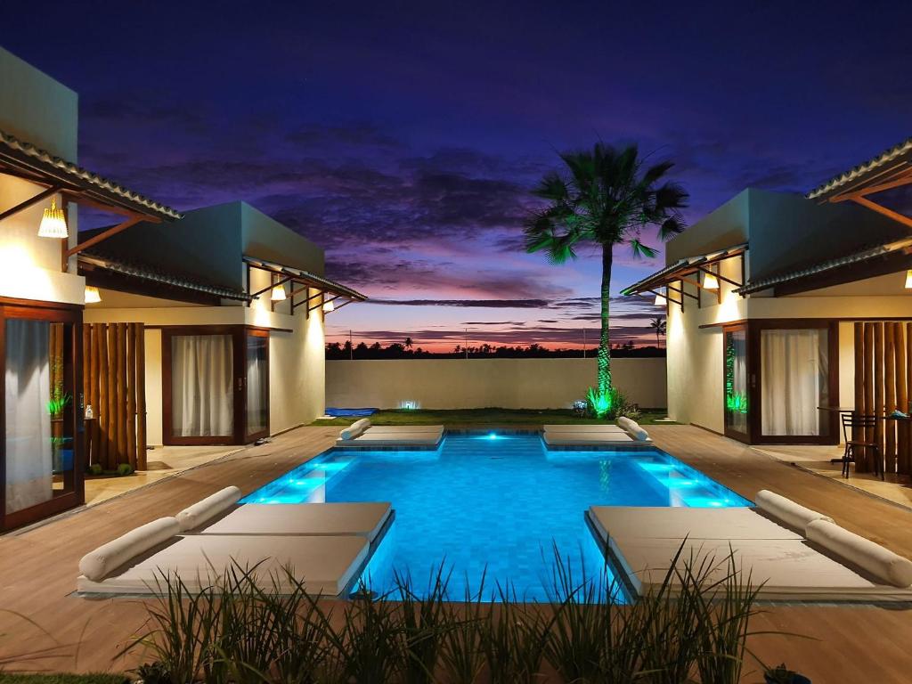 a villa with a swimming pool at night at Villa Kaitei in São Miguel do Gostoso