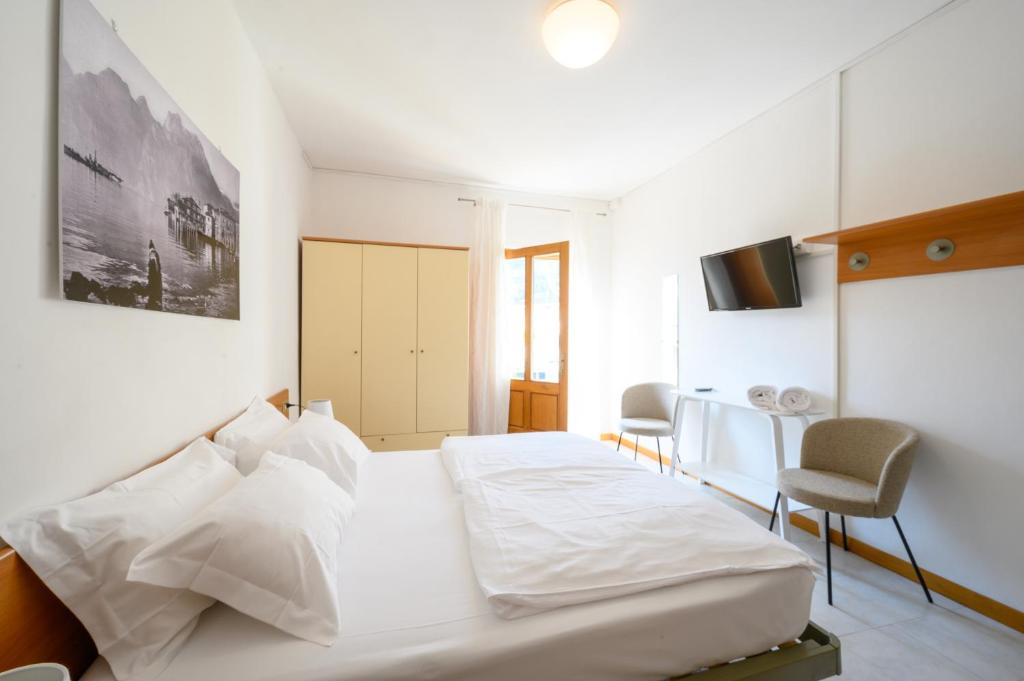 納戈－托爾博萊的住宿－Villa Nirvana，白色卧室配有床和桌椅