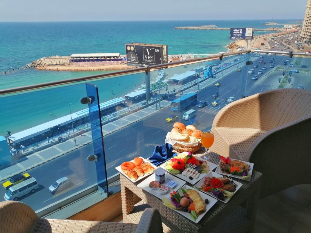 Jewel San Stefano Hotel في الإسكندرية: صينية طعام على طاولة مطلة على المحيط