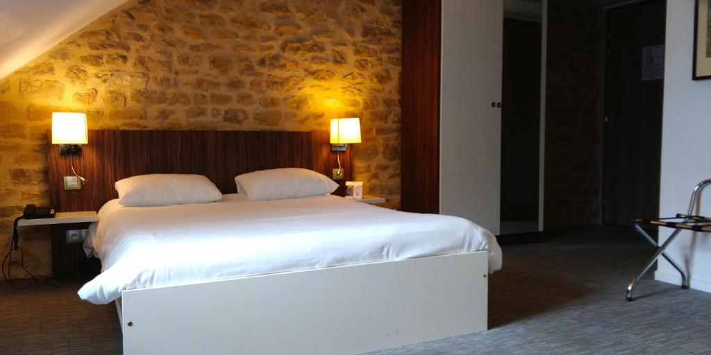sypialnia z dużym białym łóżkiem z 2 poduszkami w obiekcie The Originals City, Hôtel Le Coeur d'Or, Sedan Est (Inter-Hotel) w mieście Douzy
