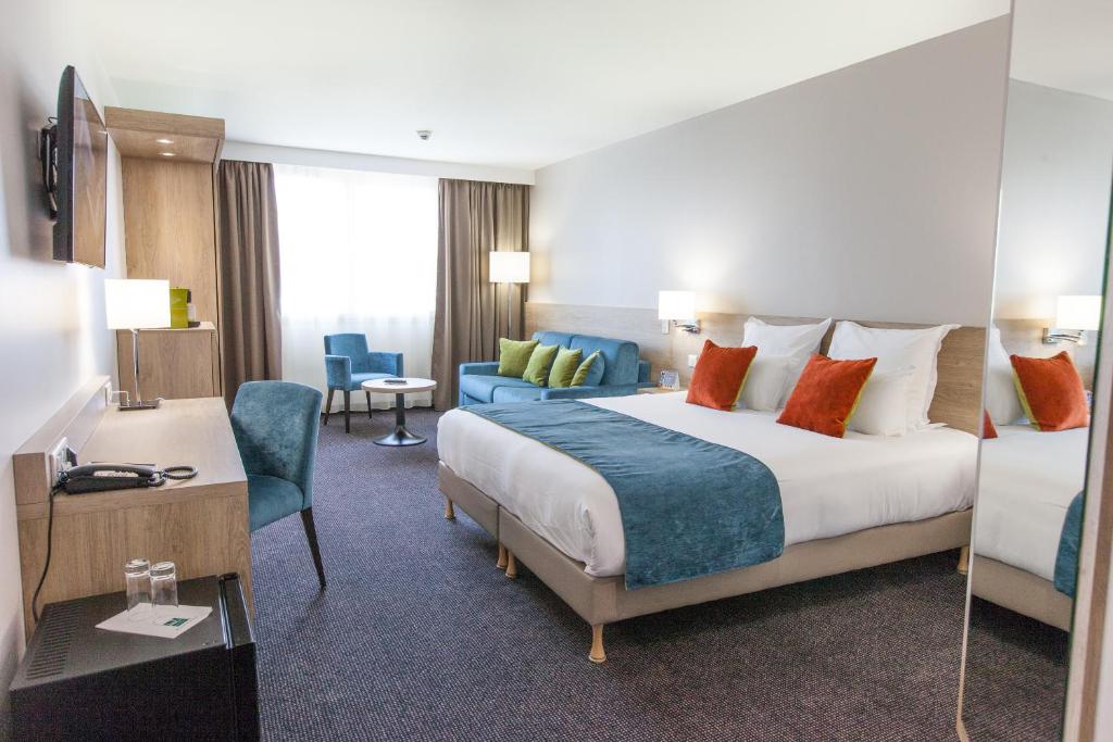 een hotelkamer met een groot bed en een bureau bij Best Western Hotel Le Bordeaux Sud in Gradignan