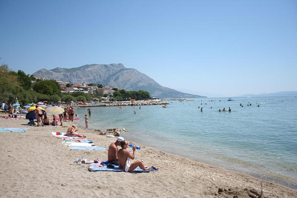 a group of people on a beach in the water at Studio Apartment in Duce with Sea View, Terrace, Air Conditioning, Wi-Fi (4167-2) in Duće