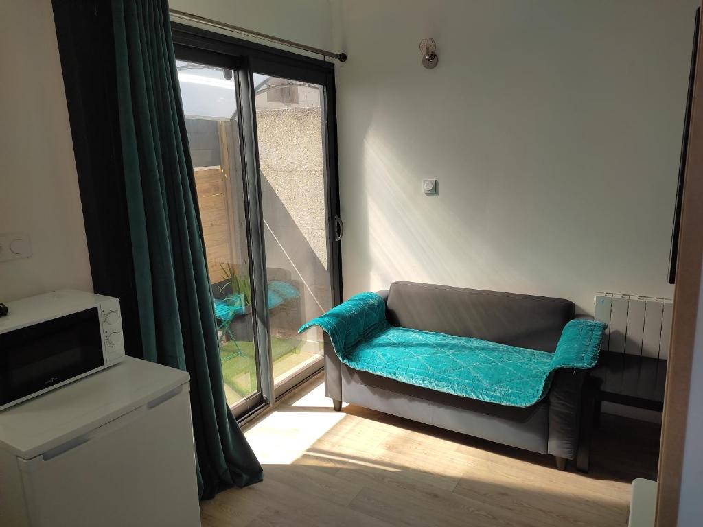 a living room with a couch and a window at Joli Studio tout équipé a votre disposition in Fleury-les-Aubrais