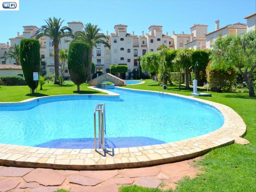 ein großer Pool in einem Park mit einem Gebäude im Hintergrund in der Unterkunft Apartamento la Isla Javea - 5008 in Jávea