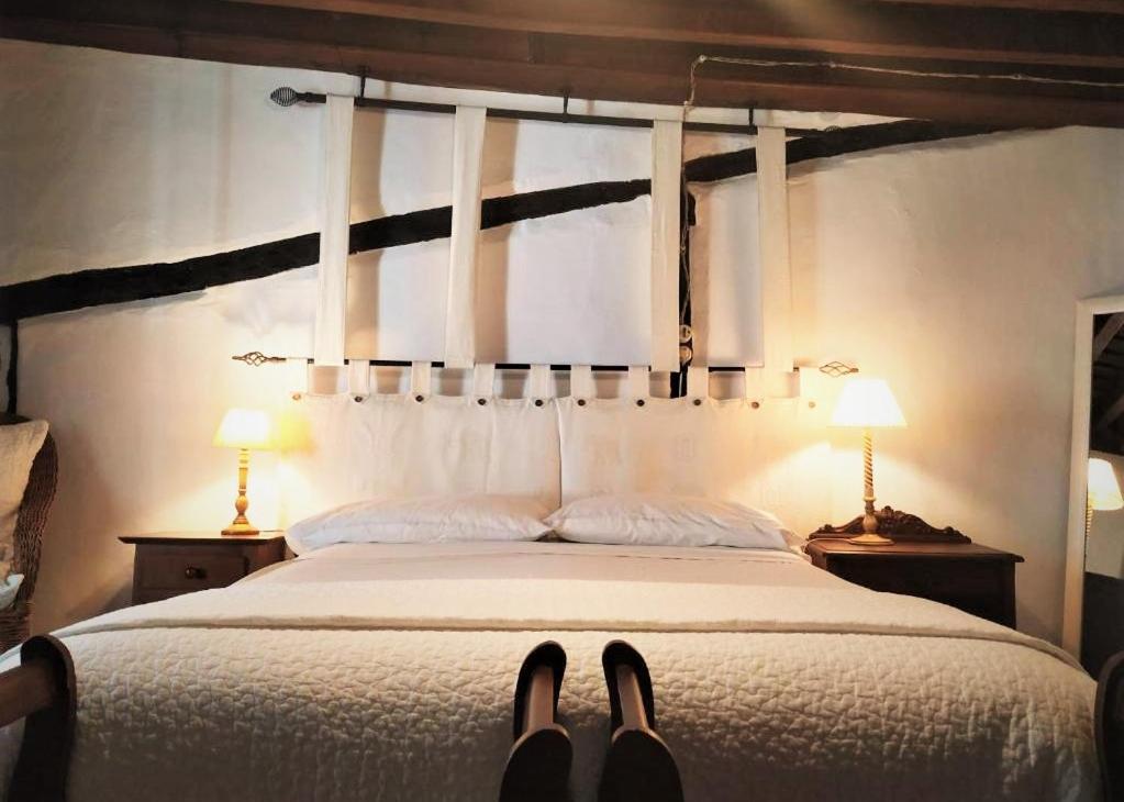 a bedroom with a bed with two lamps and two shoes at Casa Bethona in Jerte