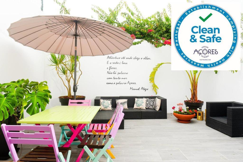 patio ze stołem, krzesłami i parasolem w obiekcie Toi et Moi-Guests speek for us! w mieście Ponta Delgada