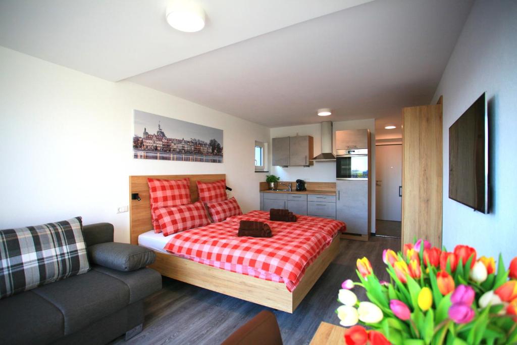 ein kleines Schlafzimmer mit einem Bett und einem Sofa in der Unterkunft Überlinger See-Apartments Apartment 1 Über-See in Überlingen