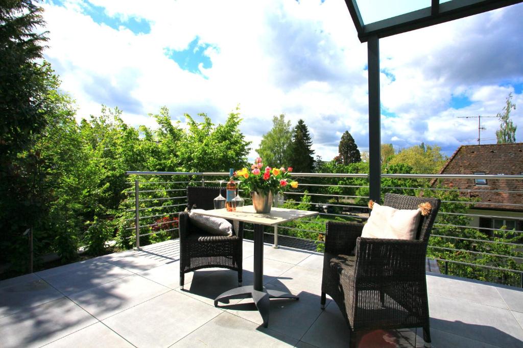 Un patio con una mesa y sillas en un balcón. en Überlinger See-Apartments Apartment 10 Über-See, en Überlingen
