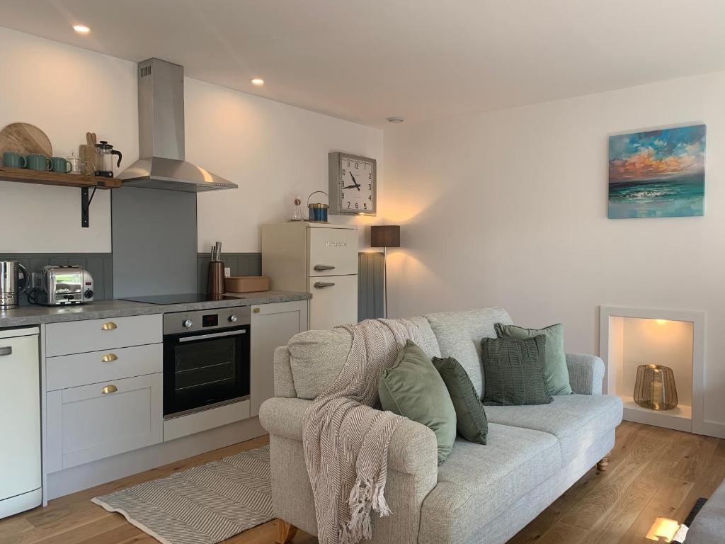 a living room with a couch and a kitchen at Orkney Staycations - Thorvald in Finstown