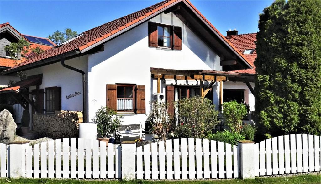 una casa blanca con una valla blanca en Landhaus Petra - Die kleine Ferienvilla, en Weitnau