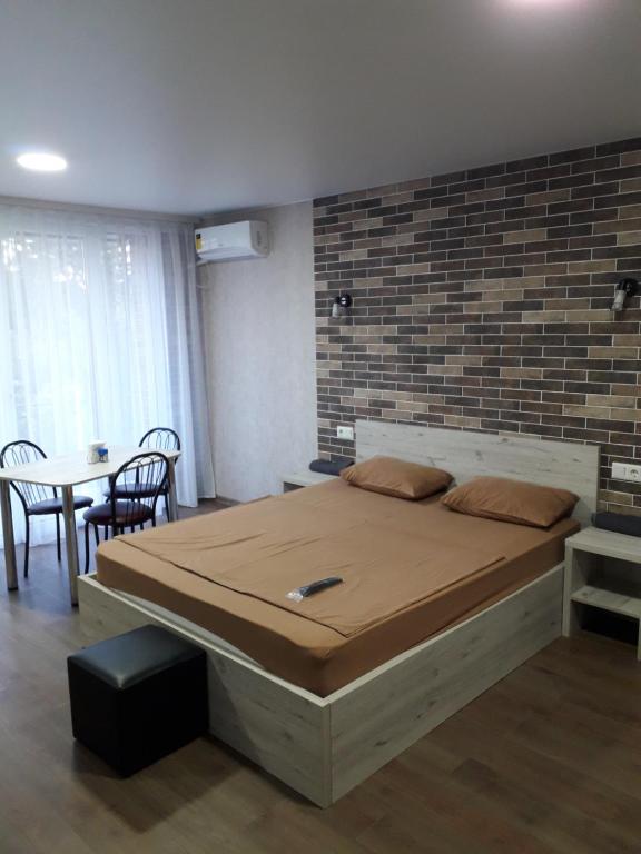 1 dormitorio con 1 cama grande y pared de ladrillo en Stefan 16-50 en Bălţi