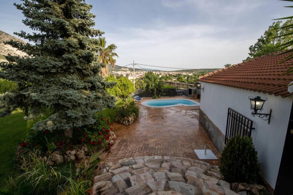 ein Haus mit einem Garten und einem Pool in der Unterkunft Casa Cuesta del Álamo. Vistas frente Puente Lata in Granada