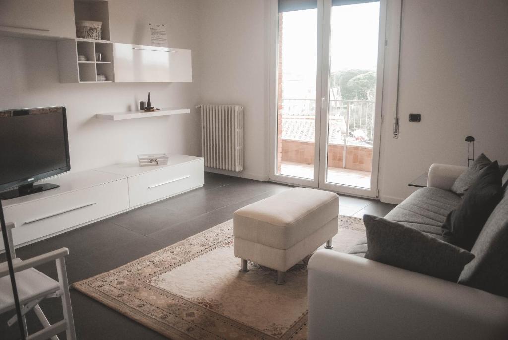 a living room with a couch and a chair and a tv at NOVA DOMUS FLAT Free Private Parking in Siena