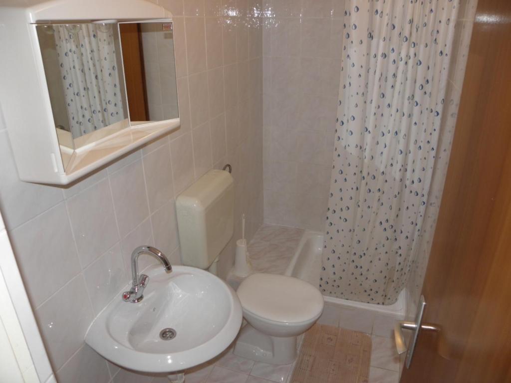 a bathroom with a toilet and a sink and a shower at Apartments Lopar (893) in Lopar