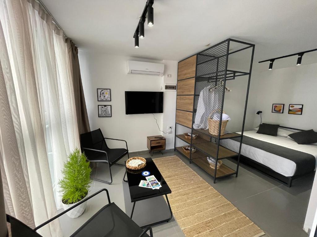 un piccolo soggiorno con un letto e un tavolo di Vela Apartament 2 a Sarandë