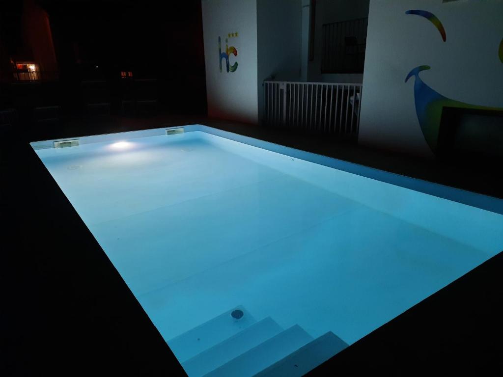 a swimming pool lit up in a dark room at Hotel I Colori in SantʼAntìoco