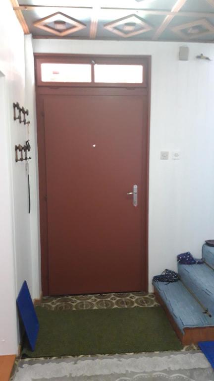 a large brown door in a room with a bench at Apartman Oasis 2 Ilidza in Sarajevo