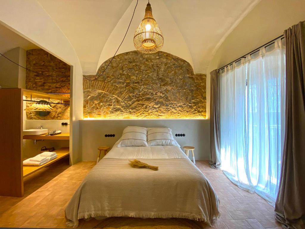 um quarto com uma cama e uma grande janela em Casa Elvira em Torroella de Montgrí