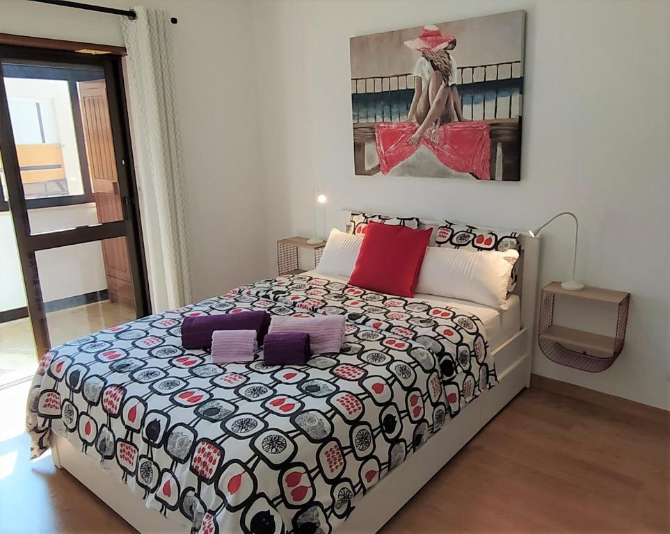 1 dormitorio con 1 cama grande con almohadas rojas y moradas en Large Apartment near the beach and Lisbon, en Costa da Caparica