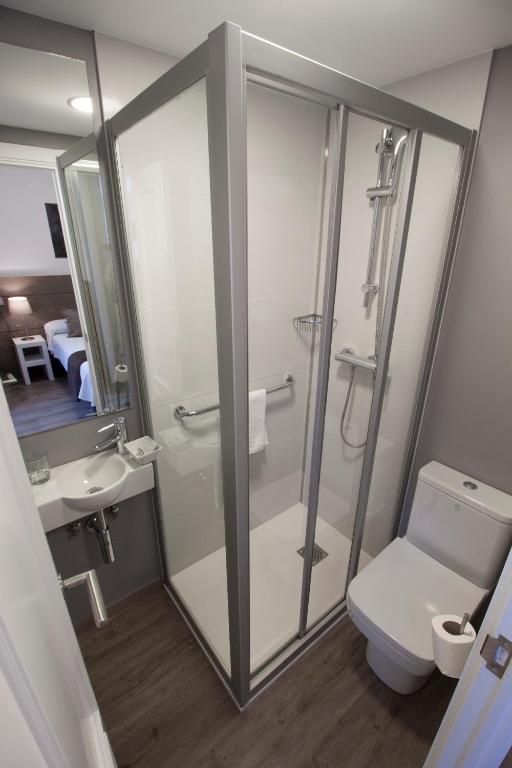 Un baño con ducha, inodoro y lavabo. en Pensión San Martin, en San Sebastián