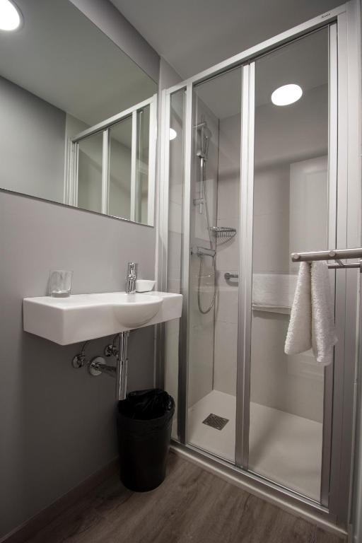 un baño con lavabo y ducha en Pensión San Martin, en San Sebastián