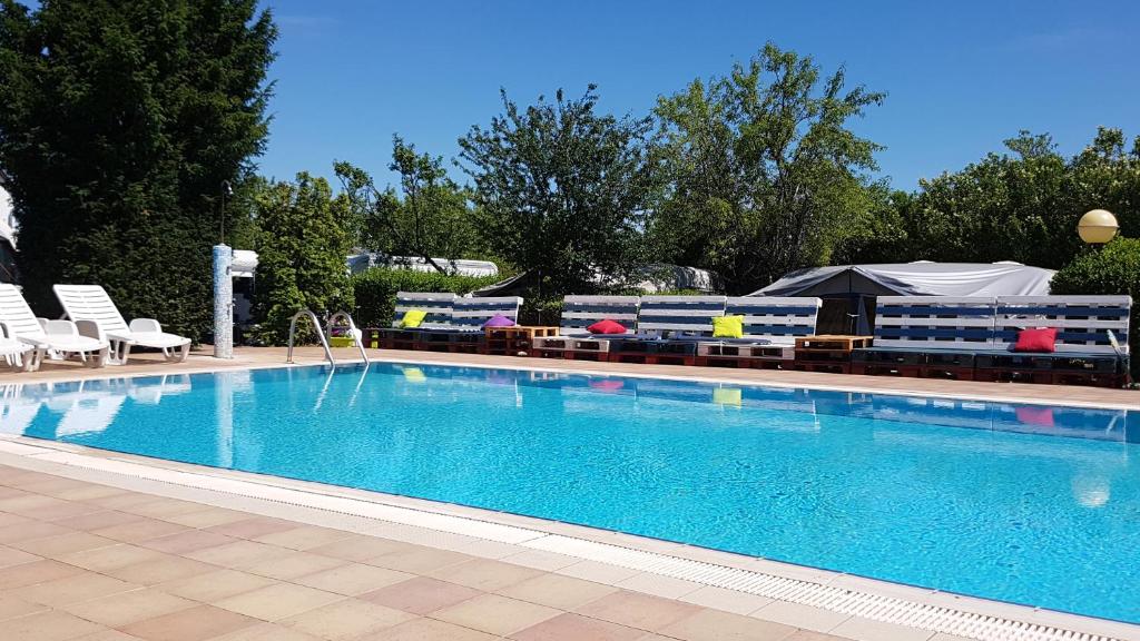 a large swimming pool with chairs and umbrellas at Mandel Faházak in Paloznak