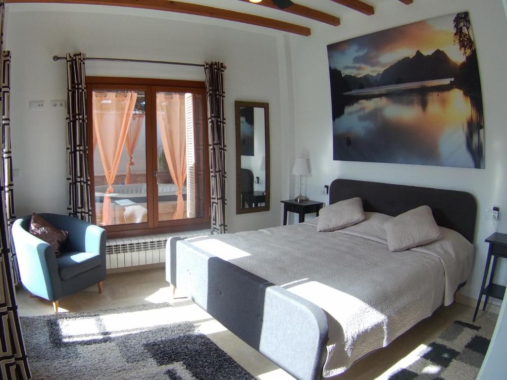a bedroom with a bed and a chair and a window at Casa Calida in Murcia