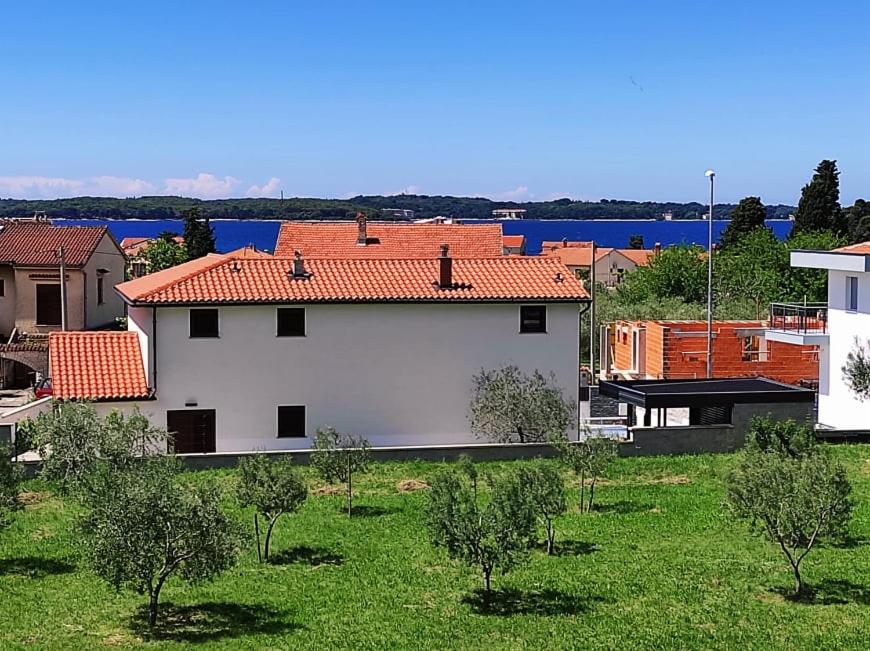 biały budynek z czerwonym dachem na dziedzińcu w obiekcie Apartment Lighthouse n3 w Fažanie