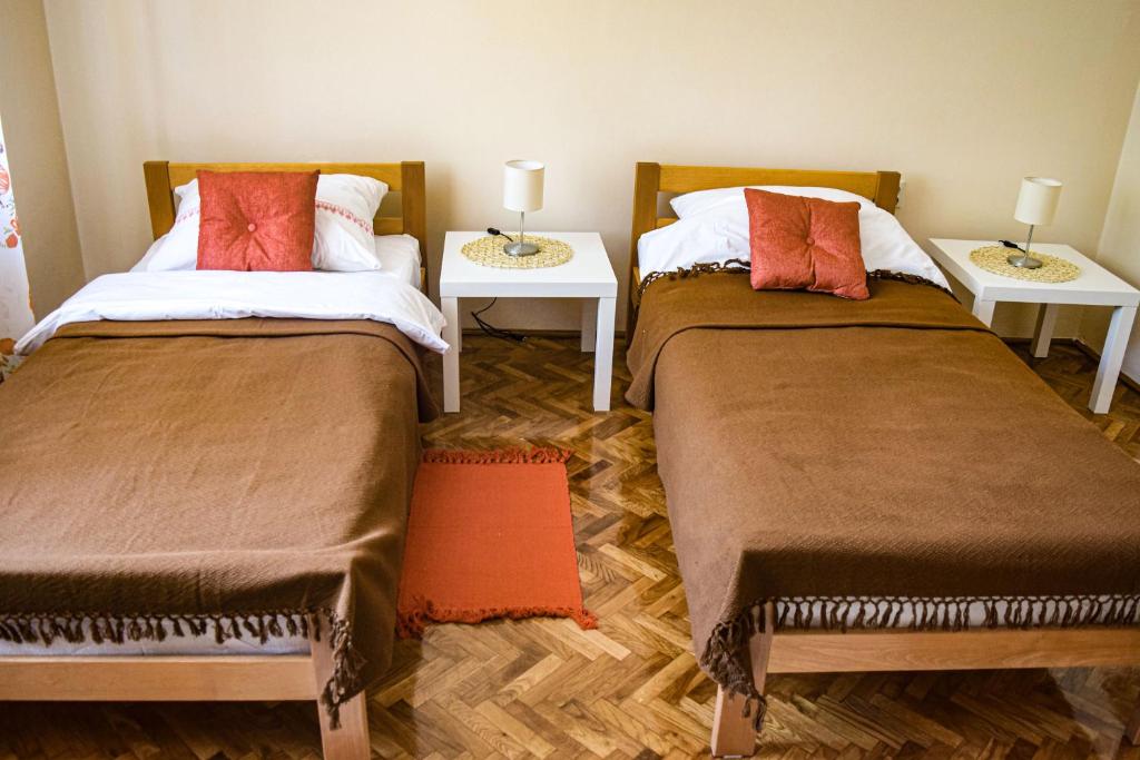 2 letti posti uno accanto all'altro in una stanza di Apartmani Jelenković a Negotin