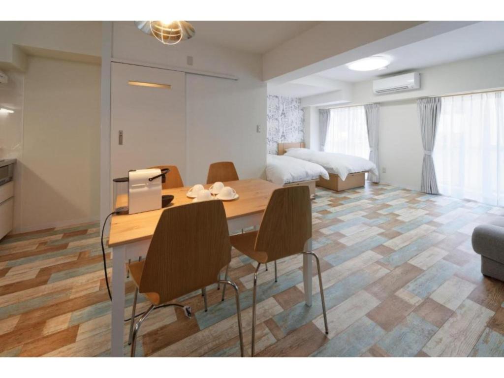 川口市にあるWALLABY HOUSE - Vacation STAY 38649vのテーブルと椅子、ベッドルーム1室が備わります。