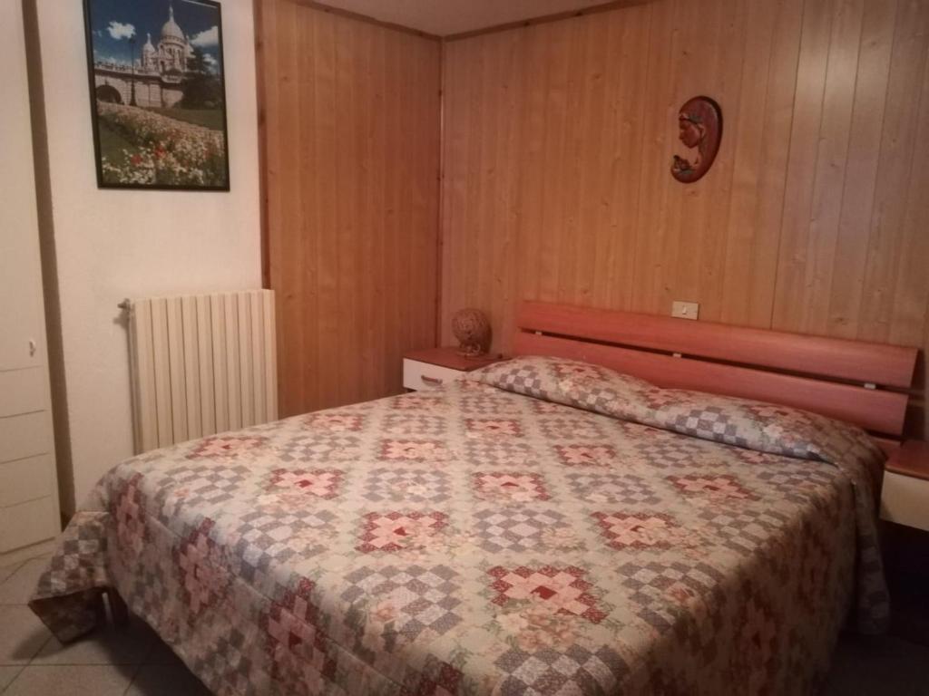 a bedroom with a bed with a quilt on it at Appartamento con vista chez Mary in Roisan