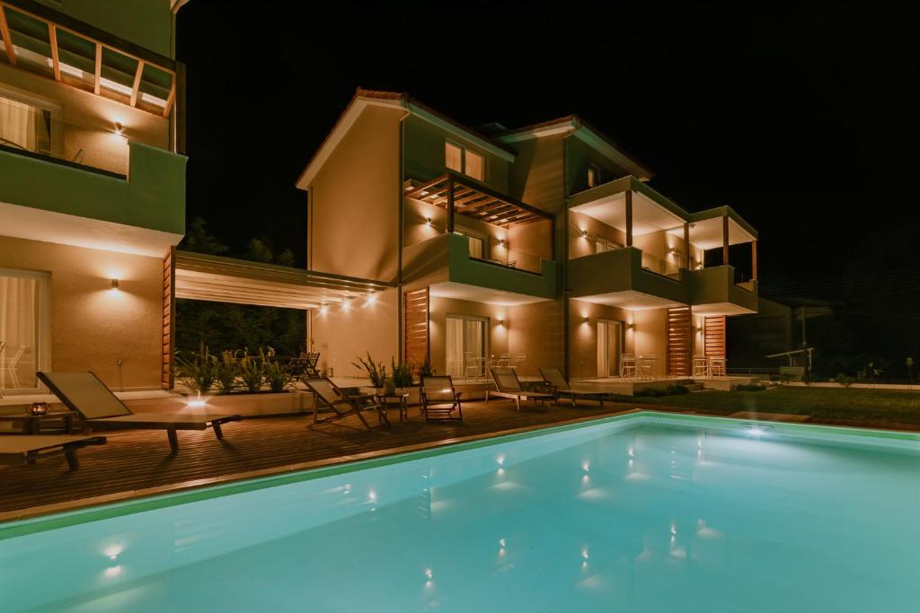 a villa with a swimming pool at night at Alion apartments in Prinos