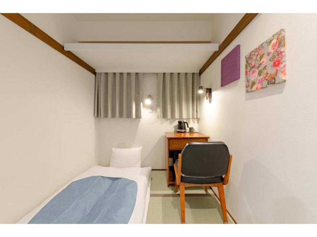 ein kleines Zimmer mit einem Bett und einem Stuhl in der Unterkunft Hotel Emit Shibuya - Vacation STAY 40886v in Tokio
