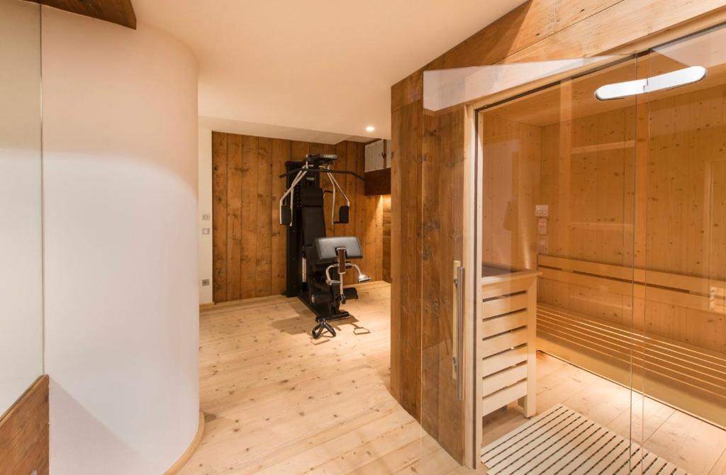 a gym with a treadmill in a room with wooden walls at Luxury Cortina in Cortina dʼAmpezzo