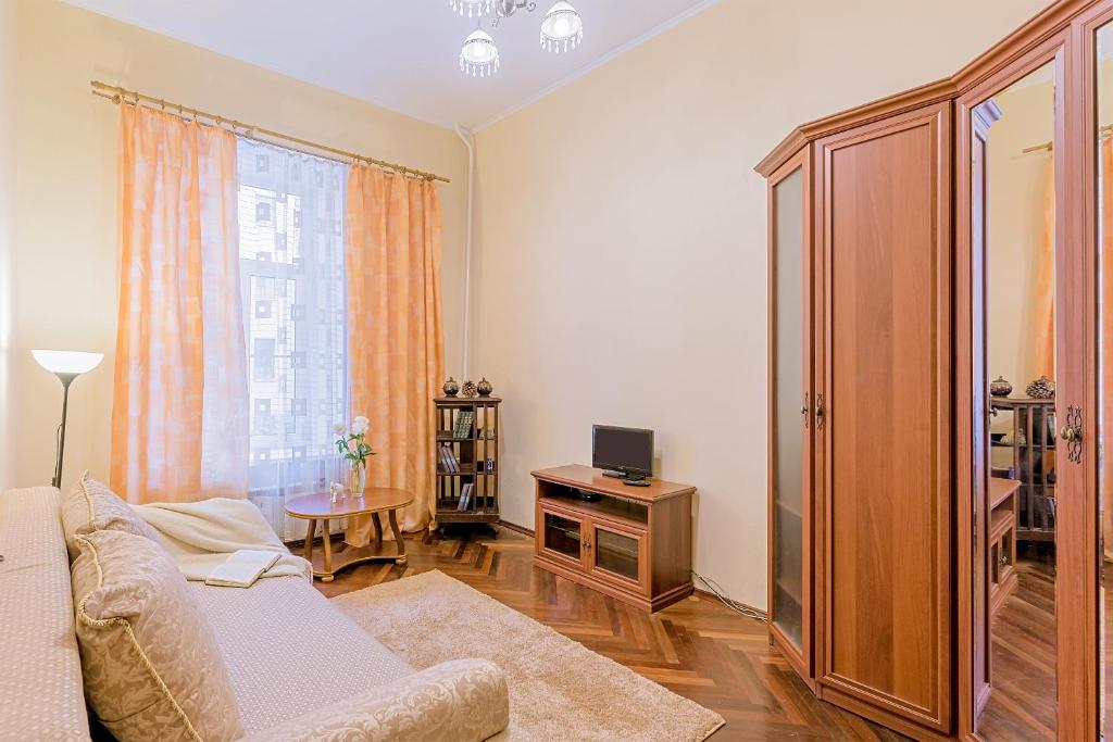 a living room with a couch and a cabinet and a television at Apartment on Pushkinskaya 17 in Saint Petersburg
