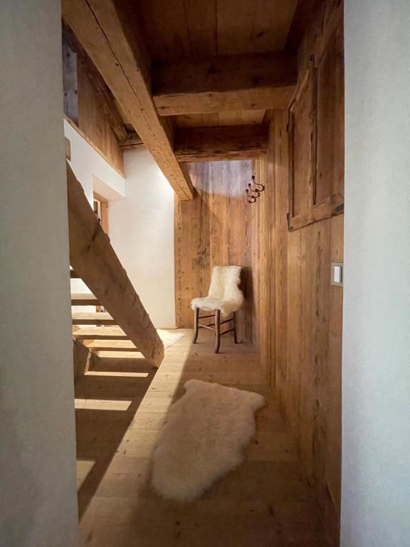 a hallway with a chair and a staircase in a room at Luxury Cortina in Cortina dʼAmpezzo